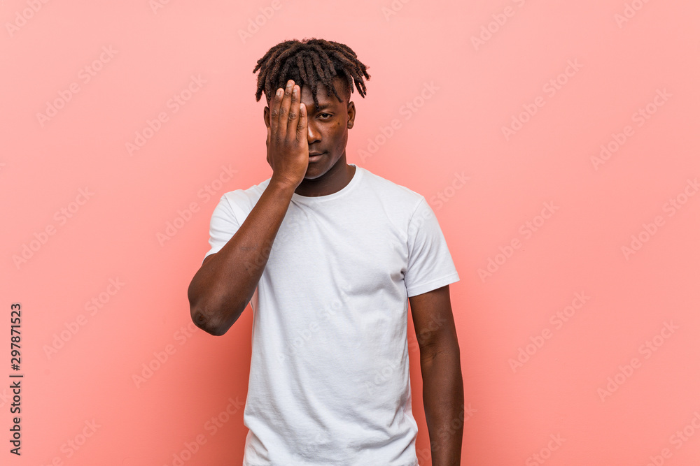 Young african black man having fun covering half of face with palm. Young african black man having fun covering half of face with palm.