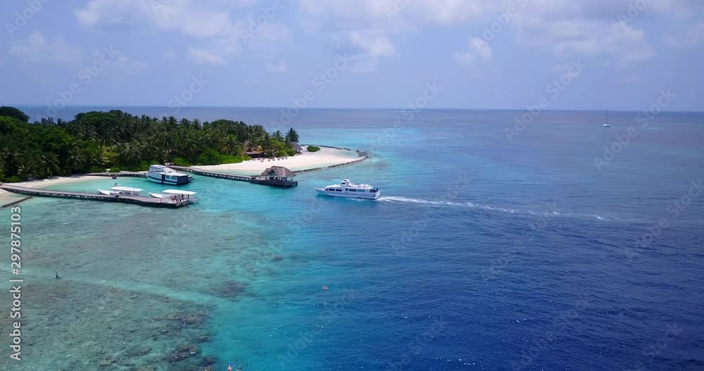 Tour boat approaching the dock pier on beautiful Maldive island. Luxurious lifestyle and vacation concept Tour boat approaching the dock pier on beautiful Maldive island. Luxurious lifestyle and vacation concept