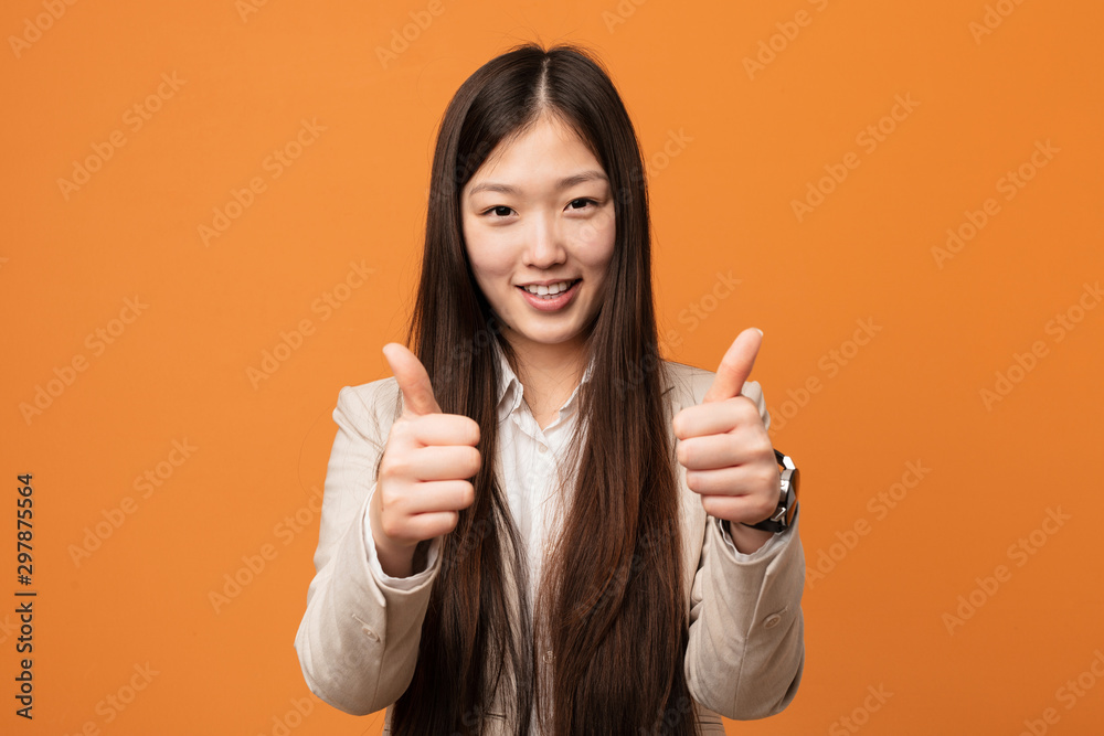 Young business chinese woman with thumbs ups, cheers about something, support and respect concept. Young business chinese woman with thumbs ups, cheers about something, support and respect concept.