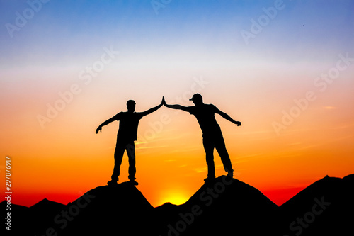 two guys stand on the tops of the mountains