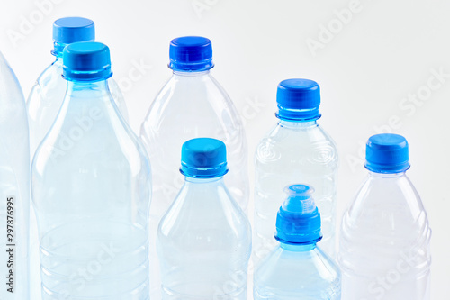 Set bottles of mineral water different types and sizes stand isolated on white background. Plastic production and processing concept