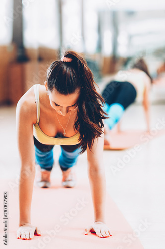 Home fitness. Brunette lady doing push ups on yoga mat.