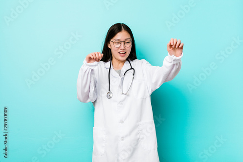 Young chinese doctor woman being shocked due to an imminent danger