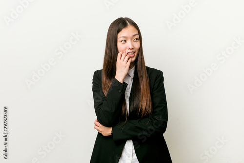 Young pretty chinese business woman relaxed thinking about something looking at a copy space.