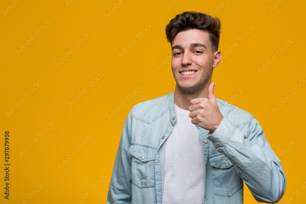 Young handsome student wearing a denim shirt smiling and raising thumb up Young handsome student wearing a denim shirt smiling and raising thumb up
