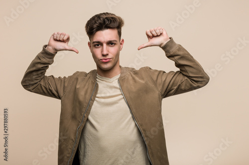 Young caucasian man wearing a brown jacket feels proud and self confident, example to follow. © Asier