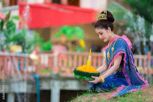 Portrait of beautiful asian woman in Thai dress traditional praying hold kratong for join loy kratong festival at thailand photo