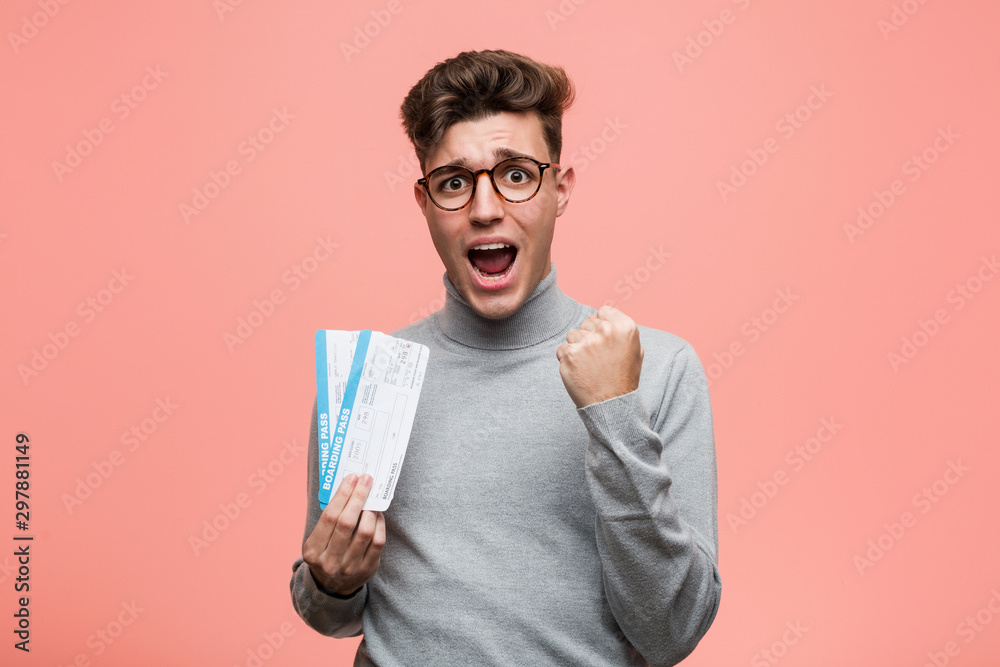 Young cool man holding an air tickets cheering carefree and excited. Victory concept. Young cool man holding an air tickets cheering carefree and excited. Victory concept.