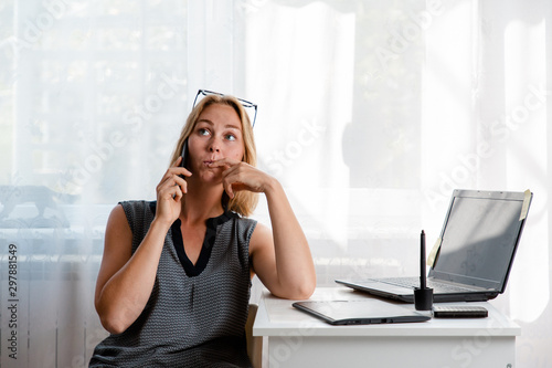 Freelance and business. Young blonde woman talking on the phone with a thoughtful face. Copy space