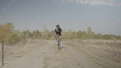 Cycling Race On Gravel Road.Cyclist Riding On Gravel Bike In Slow Motion.Bicycle Racing On Trail. Leader On Race Hurries To Finish Line.Strong Professional Cyclist Athlete On Crosscoutry Competition.  photo