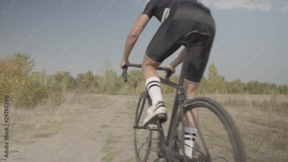 Cyclist Riding On Gravel Bike In Slow Motion.Bicycle Racing On Trail. Leader On Race Hurries To Finish Line.Cycling Race On Gravel RoadStrong Professional Cyclist Athlete On Crosscoutry Competition. Cyclist Riding On Gravel Bike In Slow Motion.Bicycle Racing On Trail. Leader On Race Hurries To Finish Line.Cycling Race On Gravel RoadStrong Professional Cyclist Athlete On Crosscoutry Competition.