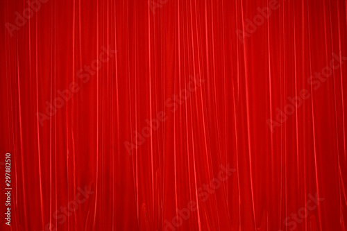 Red draped fabric. Red stage curtain. Abstract red background with vertical lines.