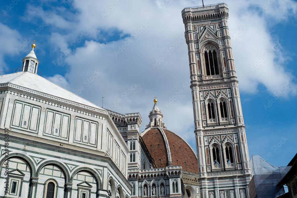 Florence's Santa Maria del Fiore, Giotto's tower, the Baptistery and cloudy blue sky.