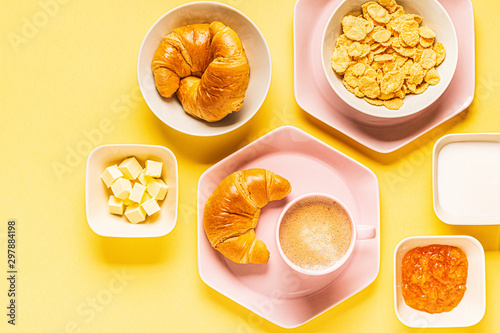 Coffee and croissants for breakfast on a yellow background