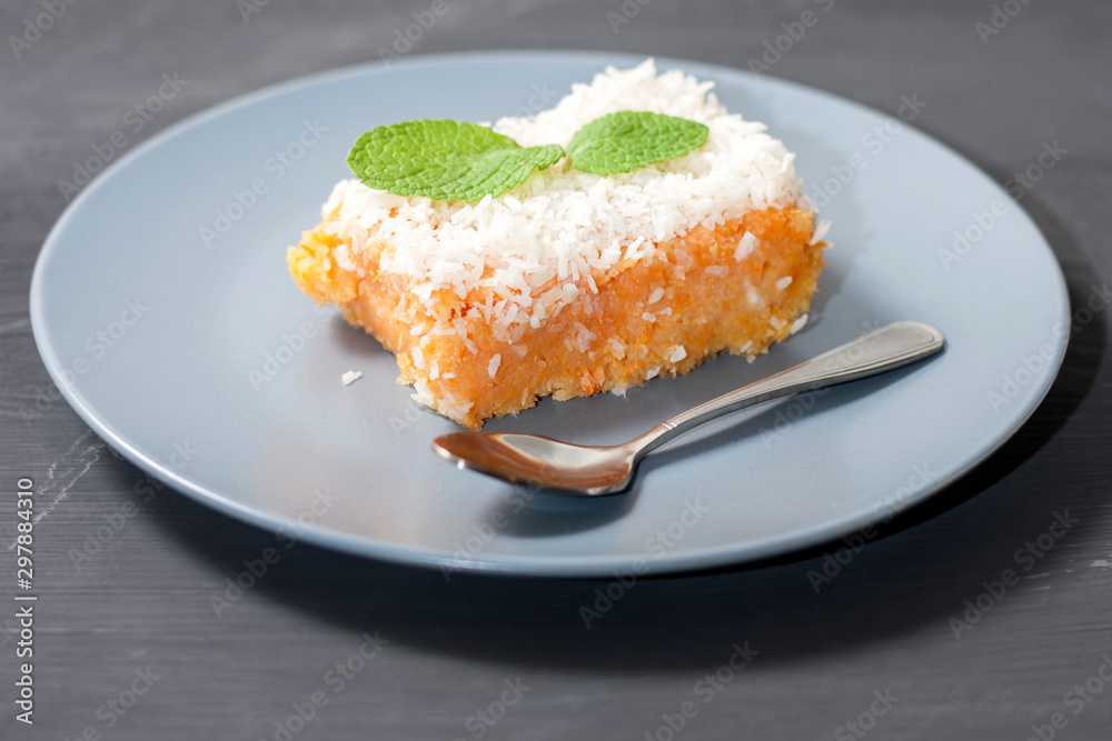 Slice of fresh homemade pumpkin pie and semolina on a grey plate on a dark background. . A Thanksgiving or holiday treat. Traditional autumn dish Slice of fresh homemade pumpkin pie and semolina on a grey plate on a dark background. . A Thanksgiving or holiday treat. Traditional autumn dish