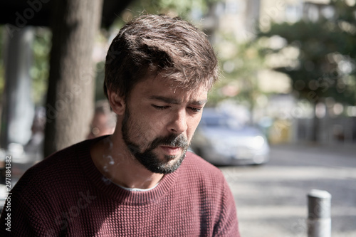 Attractive young bearded man using his smartphone in the cafe