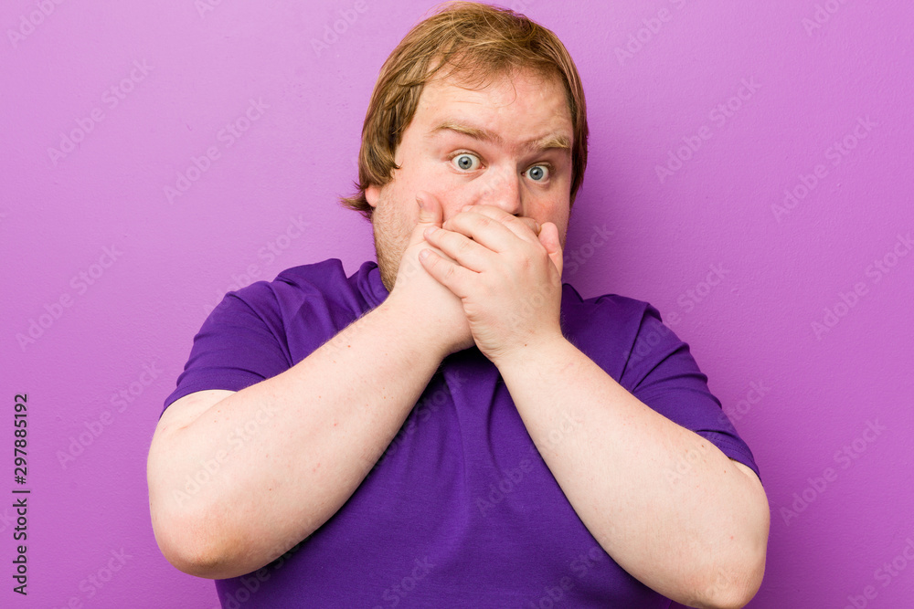 Young authentic redhead fat man shocked covering mouth with hands. Young authentic redhead fat man shocked covering mouth with hands.