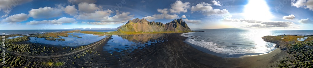 Epic aerial drone view flying over landscape of the black sand beach in Stokksnes on a sunny day. Vestrahorn mountain in the background. Nature and ecology concept background. Epic aerial drone view flying over landscape of the black sand beach in Stokksnes on a sunny day. Vestrahorn mountain in the background. Nature and ecology concept background.