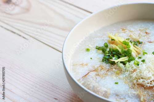 Congee, Rice porridge, Rice gruel, Rice soup, joke (China) on wooden table background, Top view, Selective and soft focus.