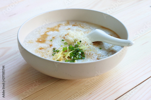 Congee, Rice porridge, Rice gruel, Rice soup, joke (China) on wooden table background, Top view, Selective and soft focus.