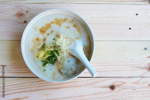 Congee, Rice porridge, Rice gruel, Rice soup, joke (China) on wooden table background, Top view, Selective and soft focus.