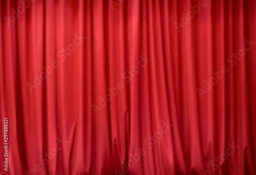 Blurred abstract red background with vertical lines. Red draped fabric. Red stage curtain.