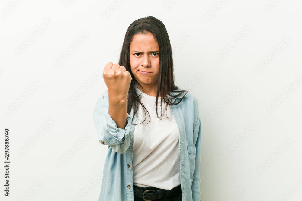 Young hispanic woman showing fist to camera, aggressive facial expression. Young hispanic woman showing fist to camera, aggressive facial expression.