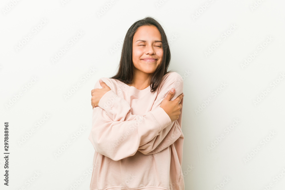 Young cute hispanic teenager woman hugs, smiling carefree and happy. Young cute hispanic teenager woman hugs, smiling carefree and happy.