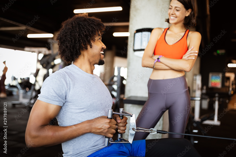 Happy fit friends exercising, working out in gym to stay healthy together Happy fit friends exercising, working out in gym to stay healthy together
