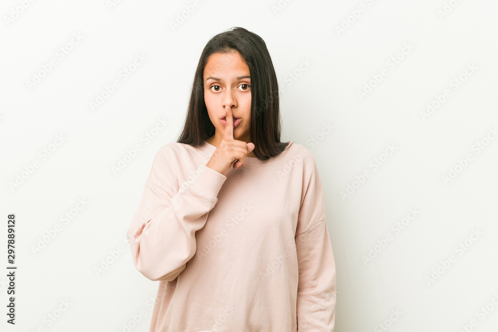 Young cute hispanic teenager woman keeping a secret or asking for silence.