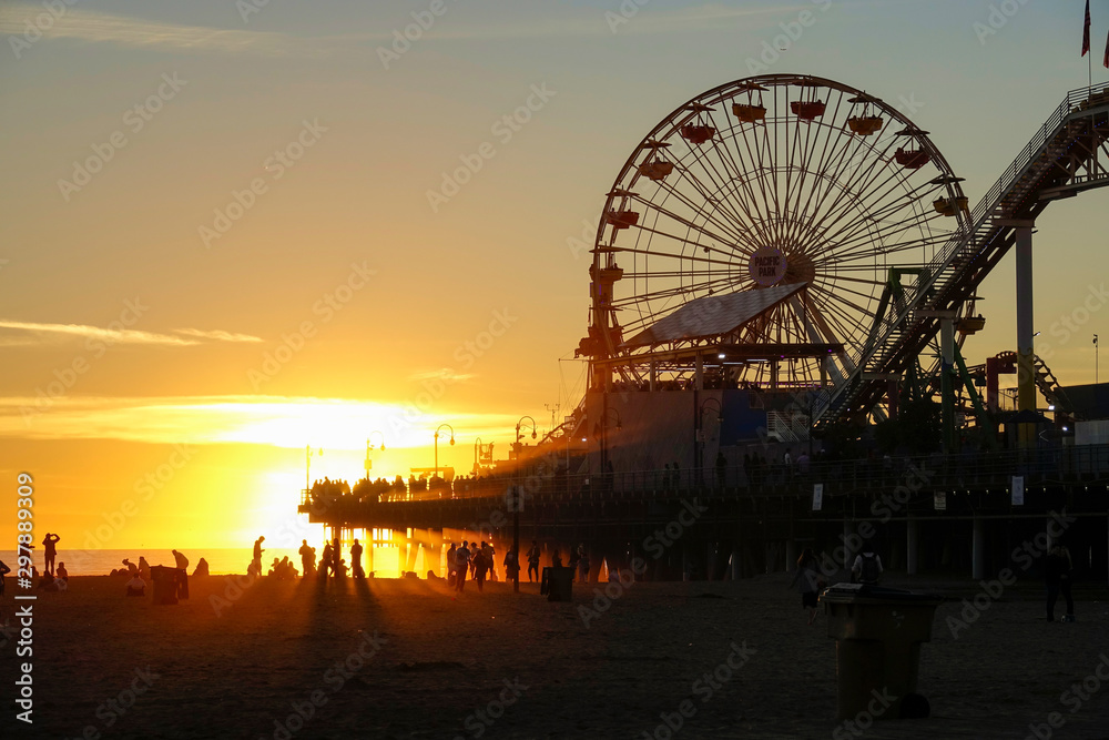 LENS FLARE: Beautiful shot of golden sun rays illuminating Santa Monica Pier.