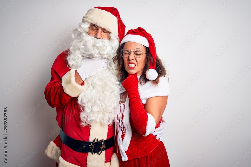 Middle age couple wearing Santa costume hugging over isolated white background Touching painful neck, sore throat for flu, clod and infection Middle age couple wearing Santa costume hugging over isolated white background Touching painful neck, sore throat for flu, clod and infection