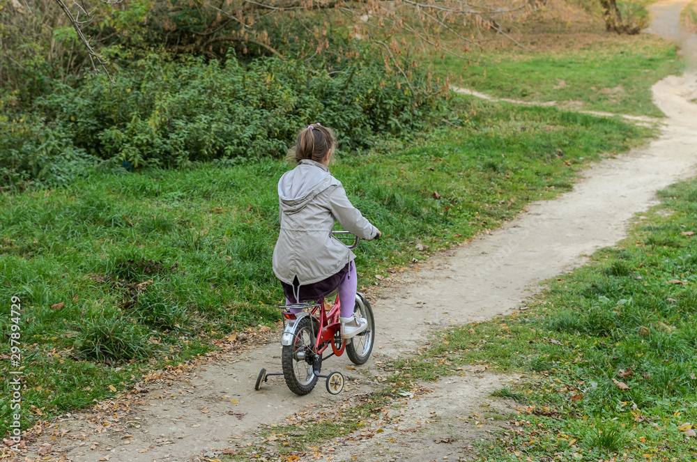 Little happy girl child rides a bicycle in the autumn forest Little happy girl child rides a bicycle in the autumn forest