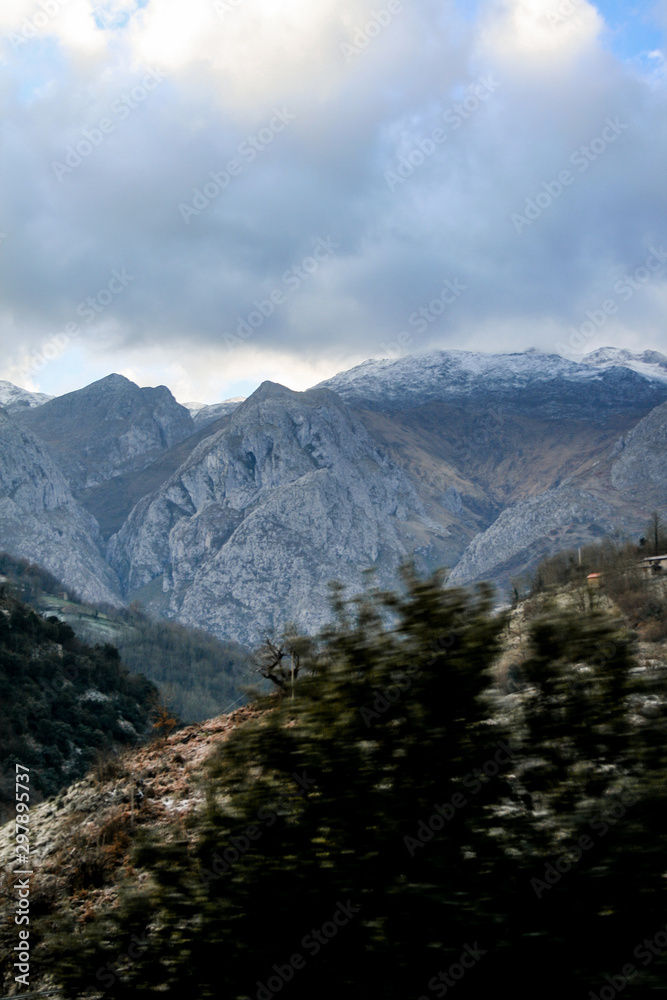 Mountain landscape in winter, with some snowy areas and mountains making a beautiful landscape and clouds in the background at sunset Mountain landscape in winter, with some snowy areas and mountains making a beautiful landscape and clouds in the background at sunset