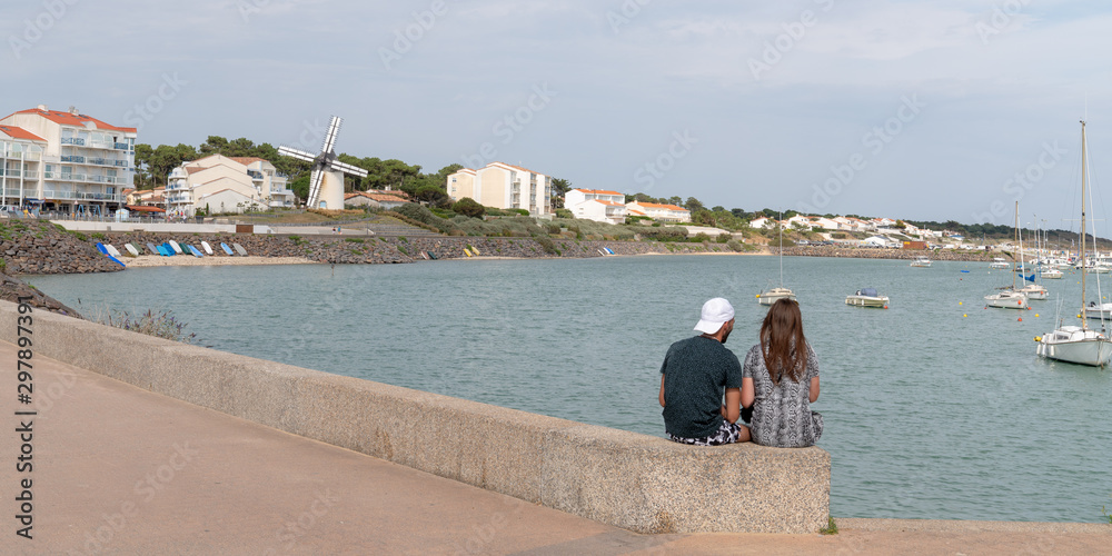 loving couple sitting on harbor vendée beach in enjoying vacation in Jard sur Mer in Vendee France in web banner template