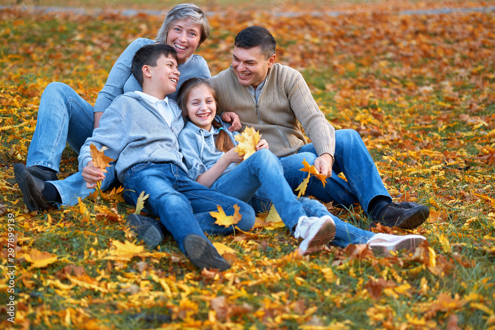 Happy family having holiday in autumn city park. Children and parents posing, smiling, playing and having fun. Bright yellow trees and leaves Happy family having holiday in autumn city park. Children and parents posing, smiling, playing and having fun. Bright yellow trees and leaves