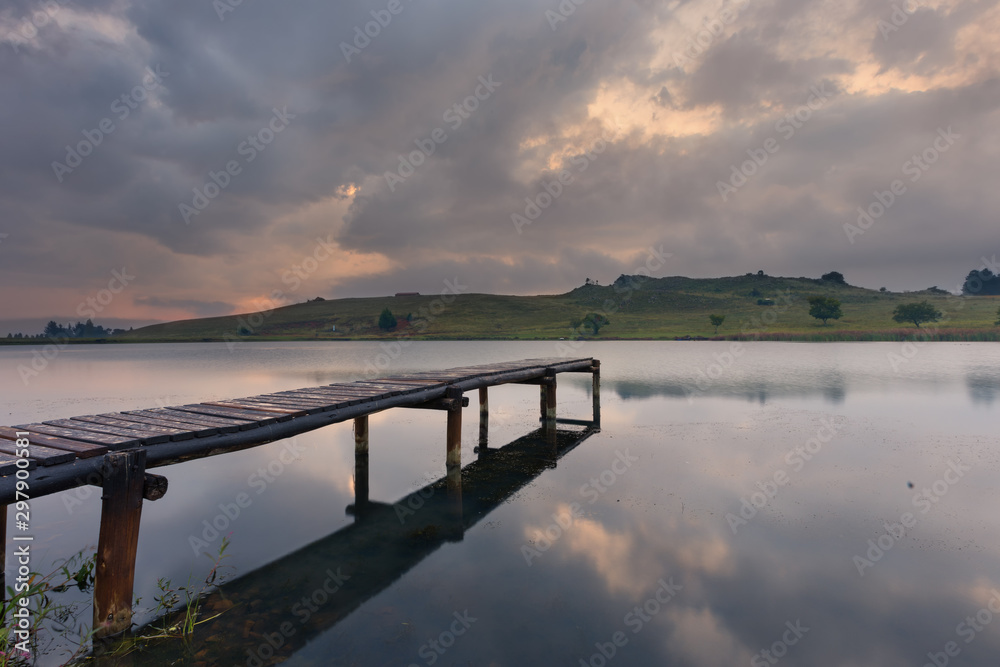Landscape of a jetty on a dam with dramatic clouds of rain storm