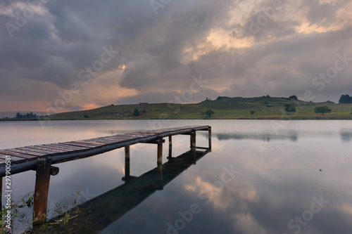 Landscape of a jetty on a dam with dramatic clouds of rain storm © Alta Oosthuizen
