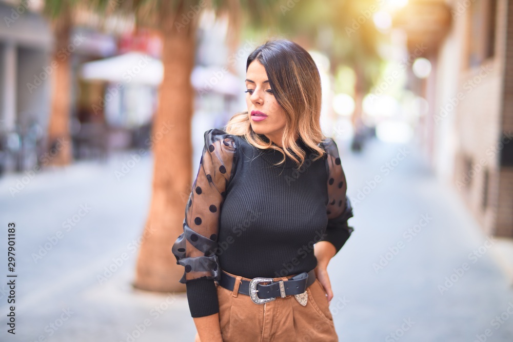 Fototapeta premium Young beautiful woman smiling happy and confident. Standing and walking at town street