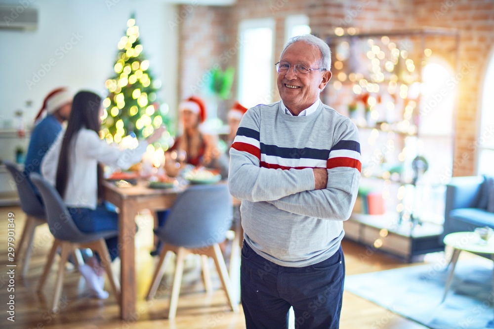 Senior handsome man smiling happy and confident. Standing with smile on face celebrating Christmas with family at home Senior handsome man smiling happy and confident. Standing with smile on face celebrating Christmas with family at home
