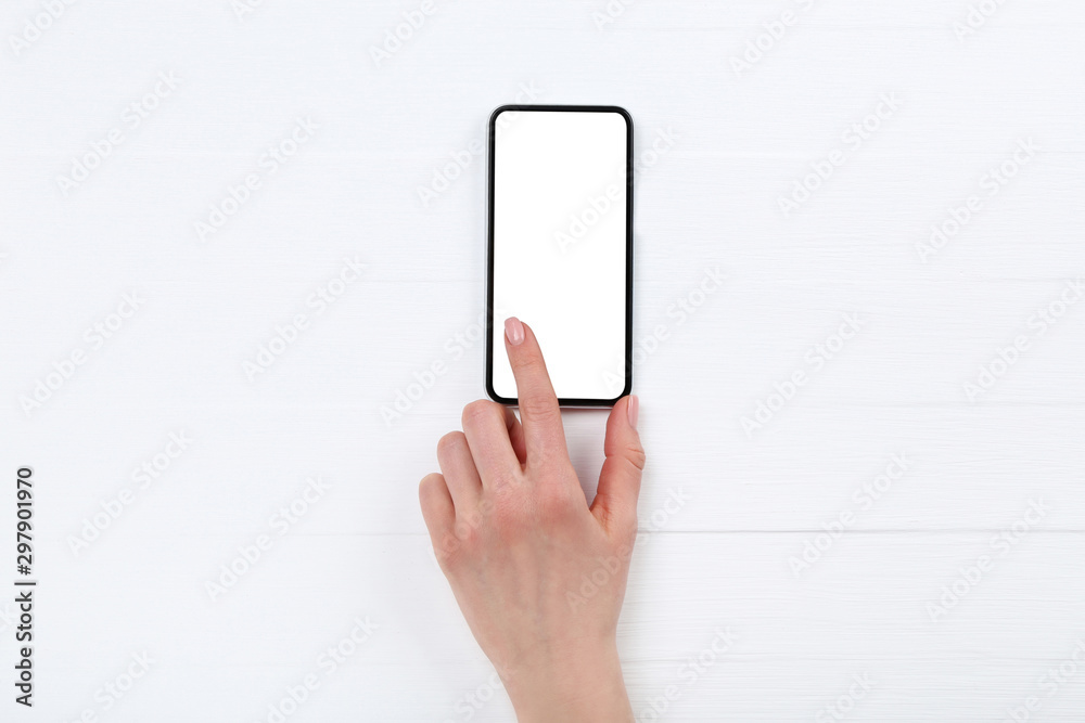 Smartphone with female hand on white wooden table Smartphone with female hand on white wooden table