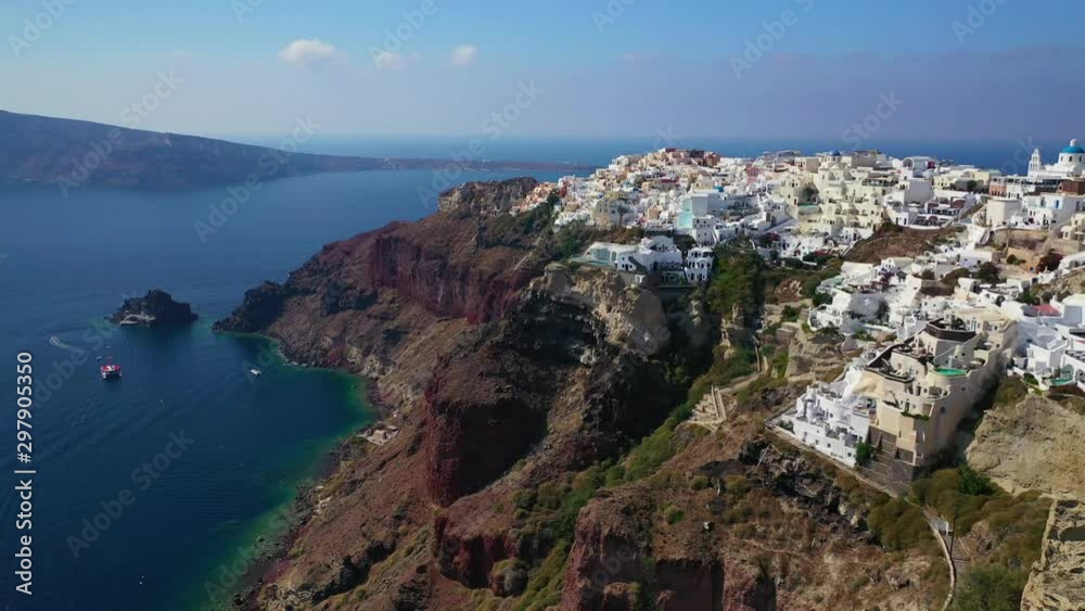 Aerial drone video of famous whitewashed and colourful at the same time picturesque village of Oia built on a cliff, Santorini island, Cyclades, Greece Aerial drone video of famous whitewashed and colourful at the same time picturesque village of Oia built on a cliff, Santorini island, Cyclades, Greece