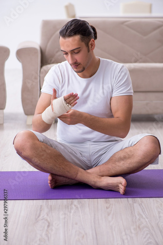 Hand injured man doing exercises at home