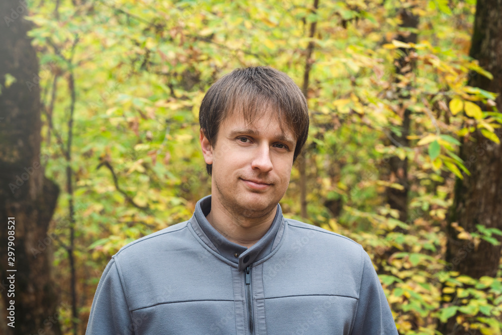 Portrait of young courageous man in autumn forest