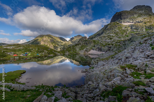 Amazing Landscape in Bulgarian mountain, reflection of the sky in the lake and tents around the lake at Rila mountain in Bulgaria.