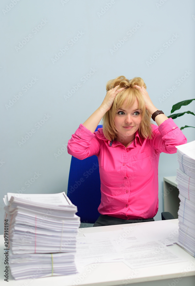 girl in the office hopelessly looking at the stack of documents girl in the office hopelessly looking at the stack of documents