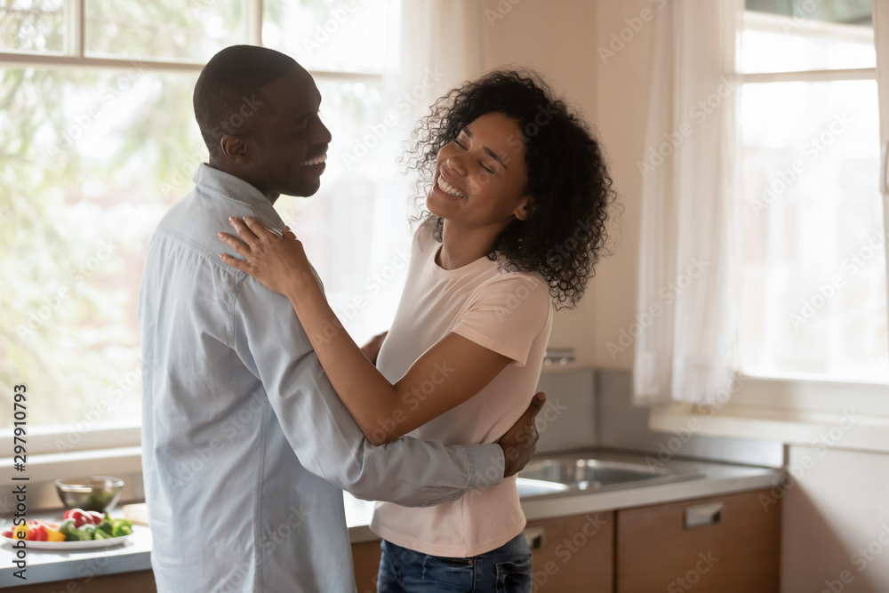 Happy mixed race couple in love dancing slowly at kitchen. Happy mixed race couple in love dancing slowly at kitchen.