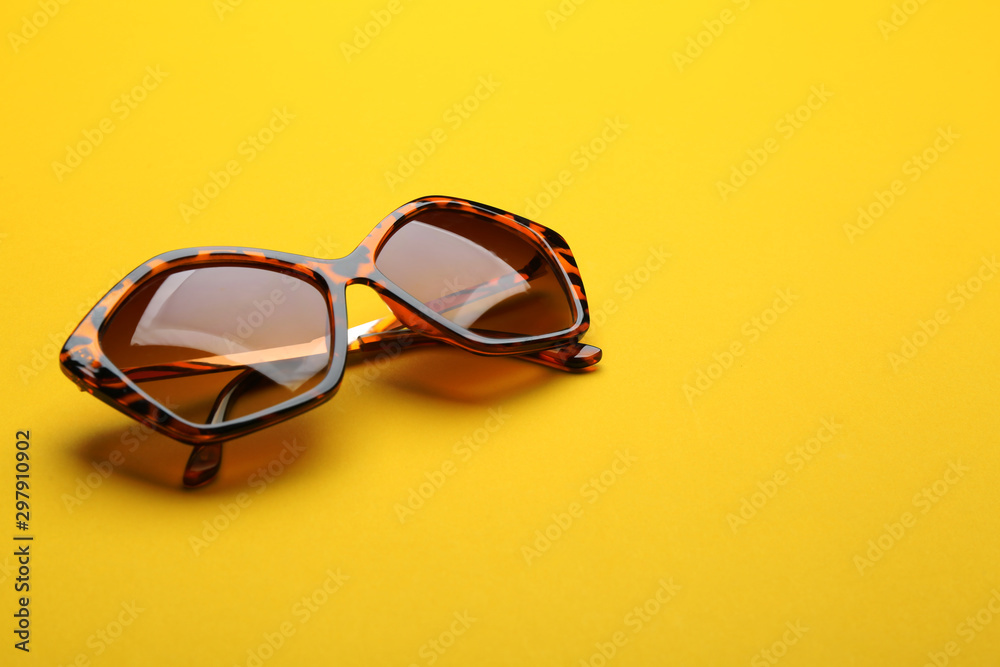 Stylish sunglasses on yellow background. Fashionable accessory Stylish sunglasses on yellow background. Fashionable accessory