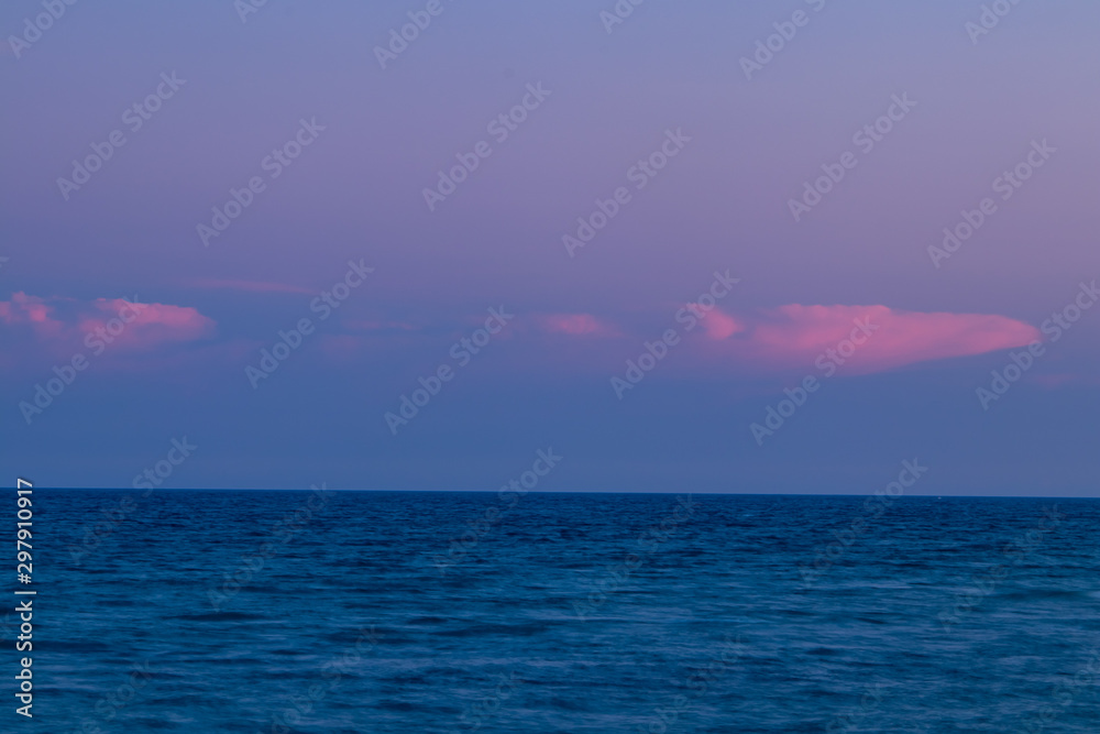 Obraz premium Sunset hour at Palm Beach, FL looking out at the ocean with pink clouds