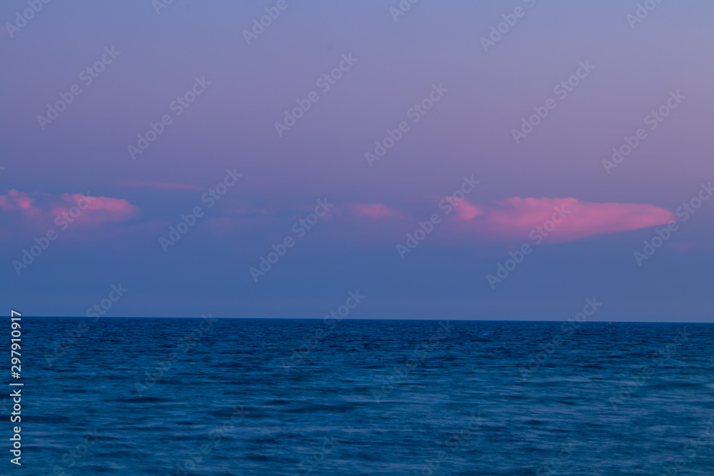 Sunset hour at Palm Beach, FL looking out at the ocean  with  pink clouds